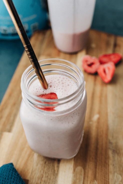 clear glass with white liquid and red straw